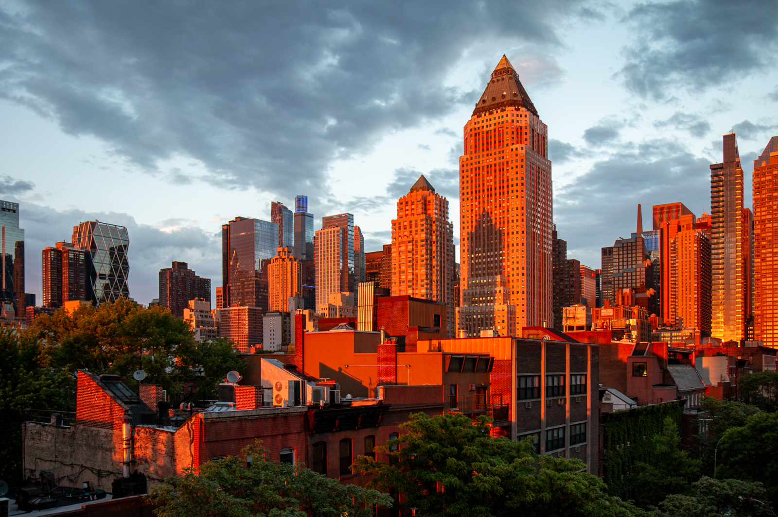 new york city, sunset, midtown west, westside, tall buildings, cityscape, apartment buildings, sky, clouds, orange hues.